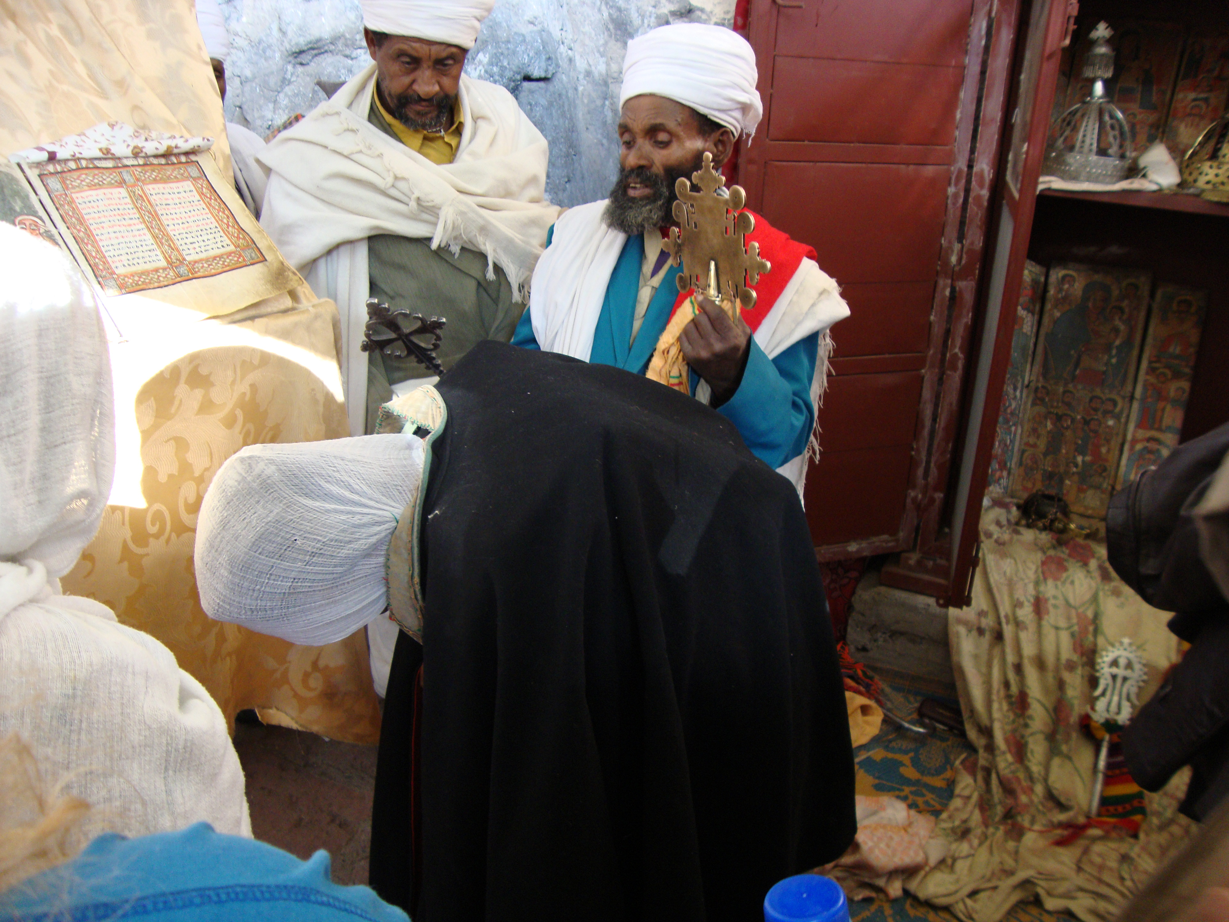 An Ethiopian priest blessing a woman with a copy of the gospels on her back, in a ceremony to bring her fertility. Photograph by Maia Sheridan, January 2013.