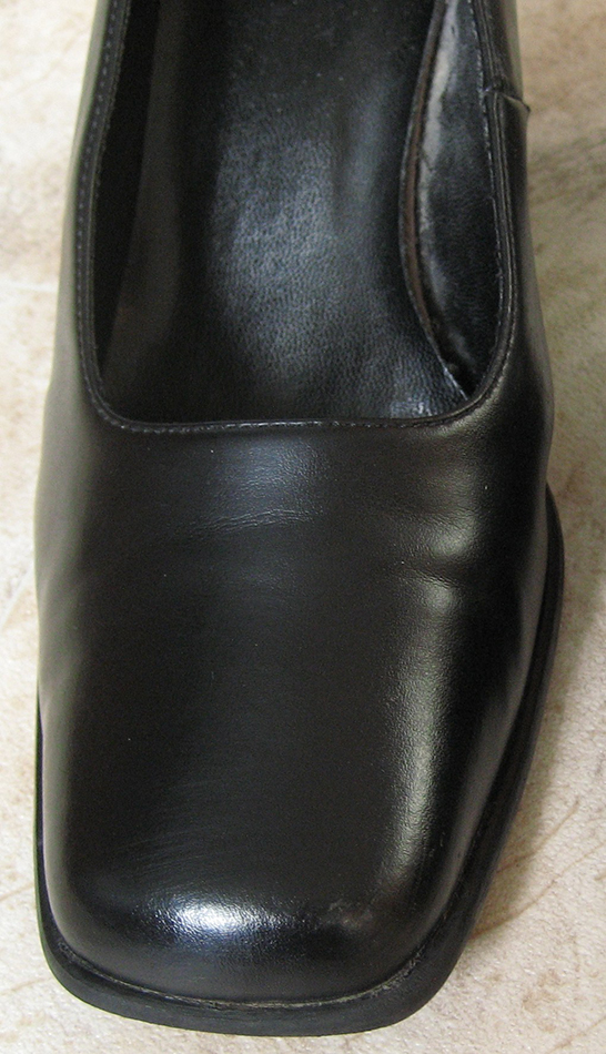 The shoe with the cheap blacking. A shine has now appeared after buffing with a polishing brush.