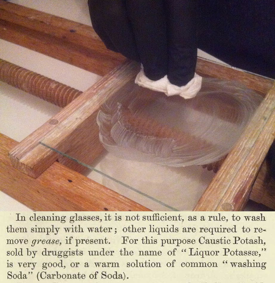 Cleaning a glass plate with sodium carbonate is best done with a wooden vice to securely hold the glass.
