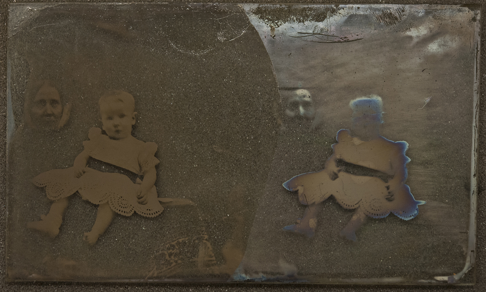 Pair of portraits, mother with small child [PHtempSB1-1]. Unvarnished half of image shows extensive tarnishing. 
