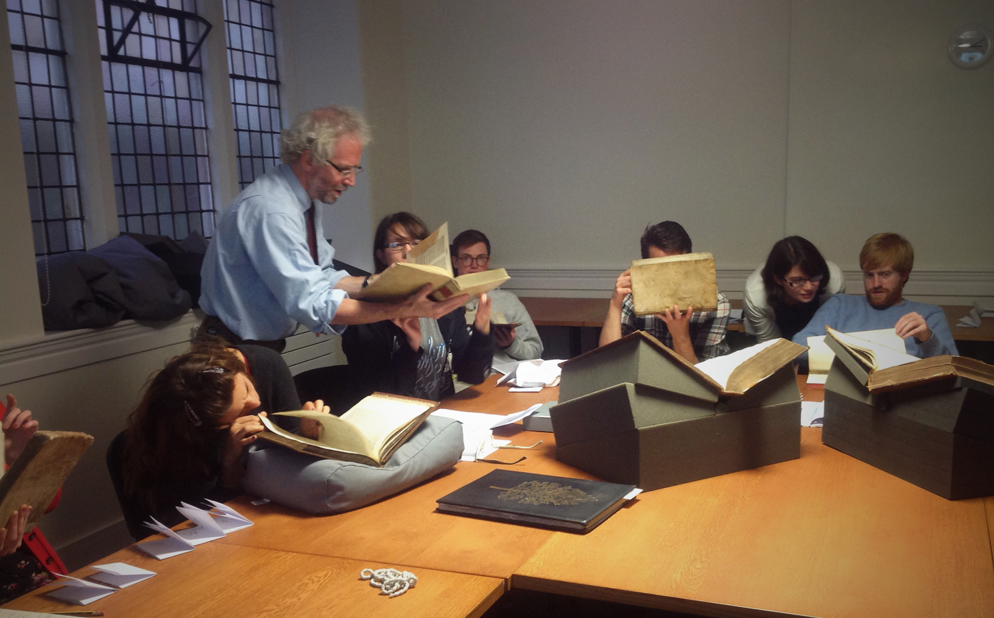 Prof. Neil Harris leads the group in  looking for watermarks in 15th and 16th century books from Special Collections.