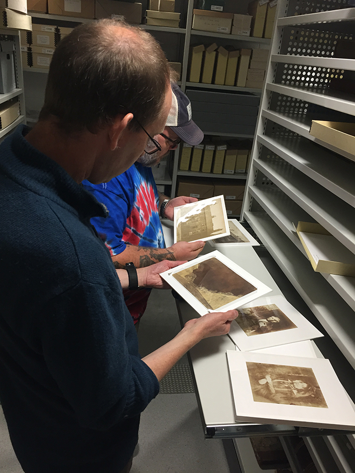 Members of The Calotype Society looking at some mounted early prints from the collection.
